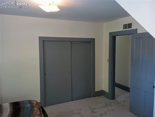 carpeted bedroom featuring visible vents and a closet