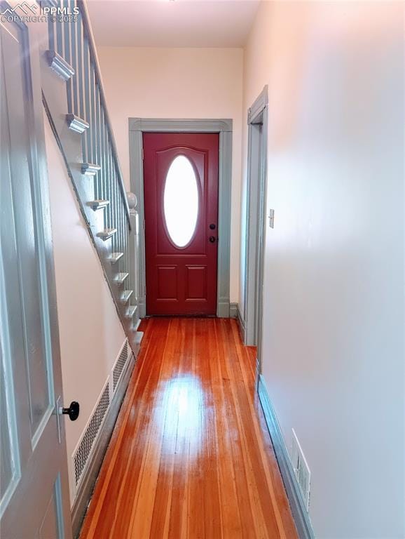 entryway featuring stairs, light wood-type flooring, visible vents, and baseboards