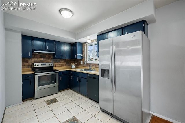 kitchen with blue cabinetry, appliances with stainless steel finishes, light countertops, and a sink