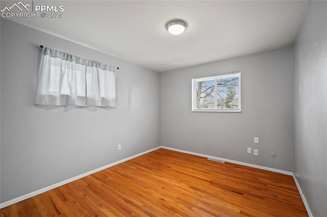 unfurnished room featuring wood finished floors and baseboards