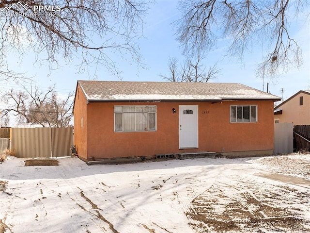 bungalow-style house featuring a gate, fence, and stucco siding