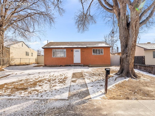 bungalow with fence and stucco siding