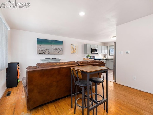 kitchen with stainless steel appliances, visible vents, light wood-style floors, and gray cabinetry