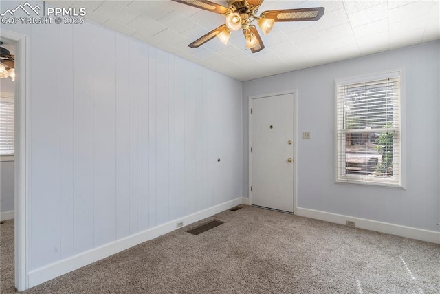 spare room featuring ceiling fan, carpet floors, visible vents, and baseboards