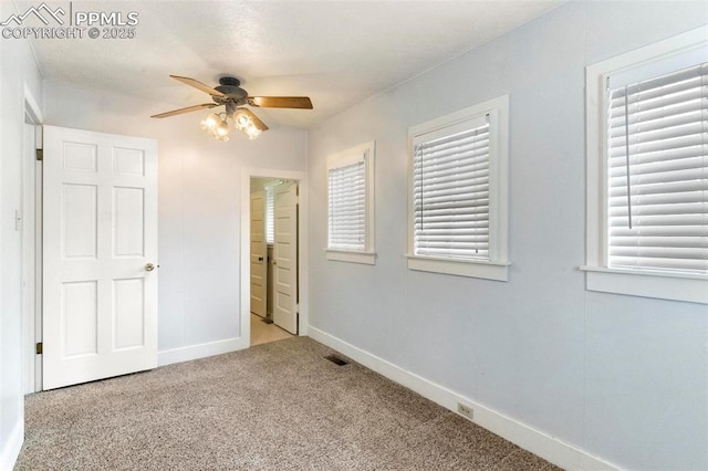 unfurnished bedroom featuring multiple windows, carpet flooring, and baseboards