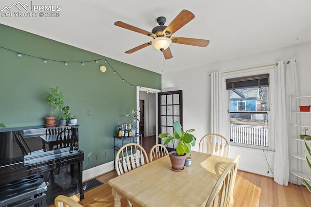 dining space featuring light wood-style flooring, baseboards, and ceiling fan