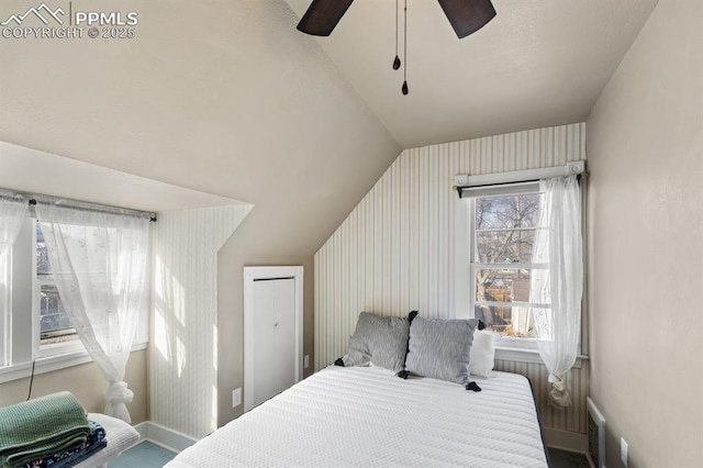 bedroom featuring vaulted ceiling, a ceiling fan, and baseboards