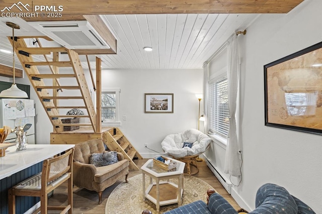 living area with visible vents, baseboard heating, wood ceiling, wood finished floors, and stairs