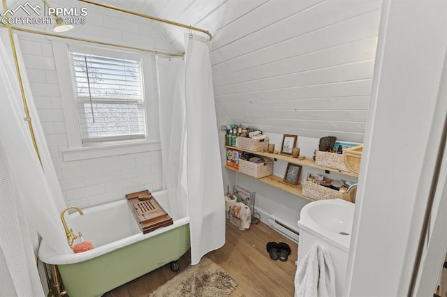 bathroom with lofted ceiling, a baseboard heating unit, shower / bath combo, and wood finished floors