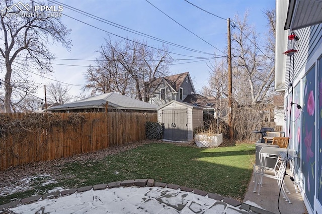 view of yard featuring fence private yard, a storage unit, and an outdoor structure