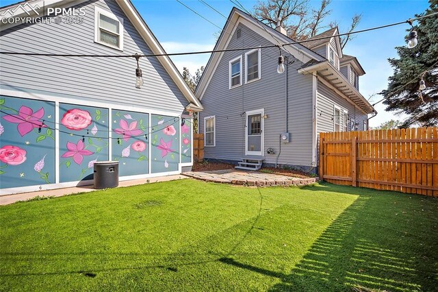 rear view of property featuring a yard, entry steps, and fence