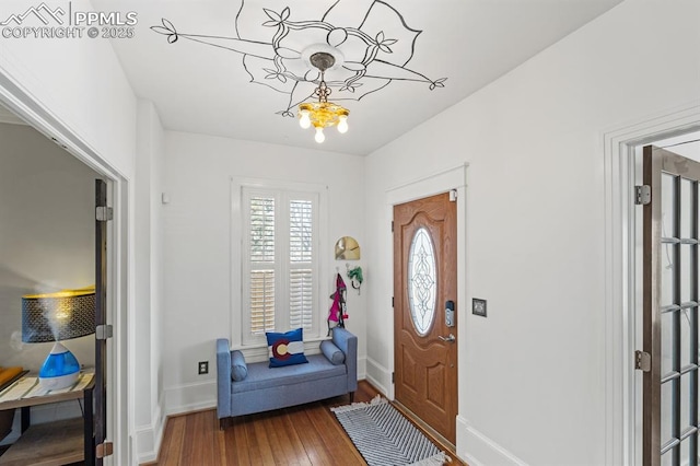 foyer entrance with a chandelier, baseboards, and hardwood / wood-style floors