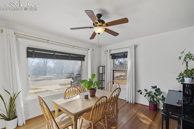 dining area with a ceiling fan, baseboards, and wood finished floors