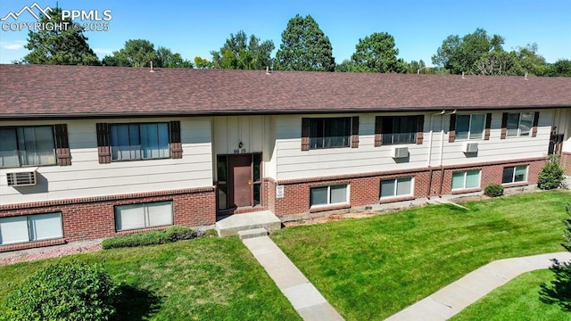 raised ranch with brick siding, a front yard, and roof with shingles