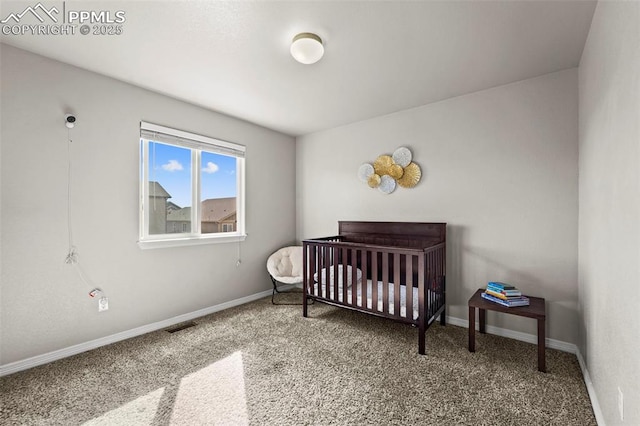 carpeted bedroom with visible vents, a crib, and baseboards