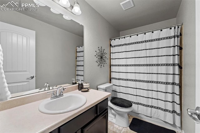 bathroom with toilet, a textured wall, visible vents, and vanity