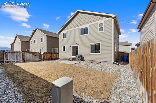 back of house with a fenced backyard and a patio