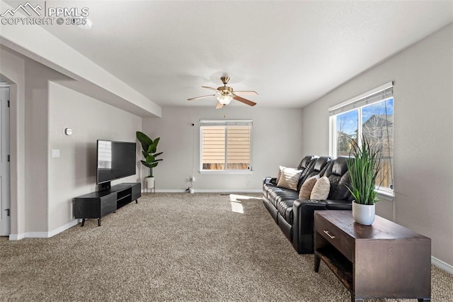 carpeted living area with baseboards and a ceiling fan