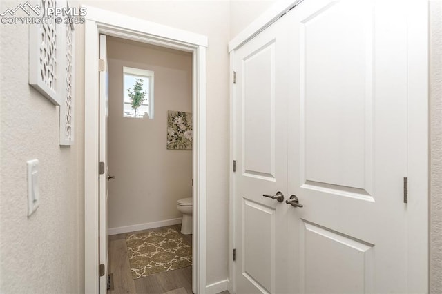 hall featuring wood finished floors and baseboards