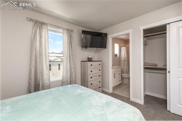 bedroom with baseboards, ensuite bathroom, a closet, and carpet flooring