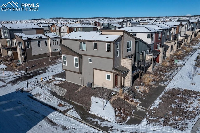 snowy aerial view featuring a residential view