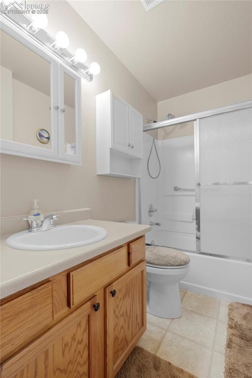 full bathroom with tile patterned floors, vanity, toilet, and bath / shower combo with glass door