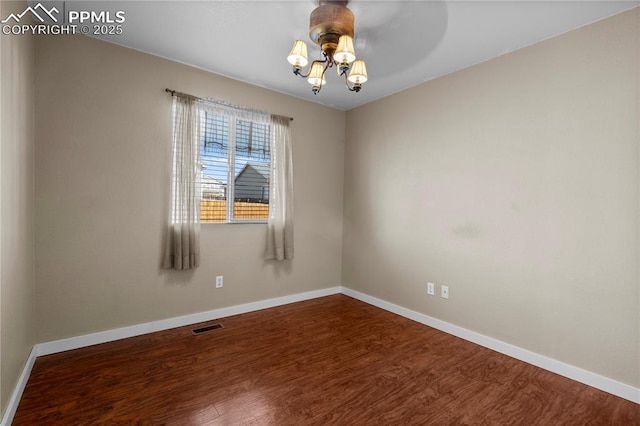 spare room with visible vents, baseboards, and wood finished floors