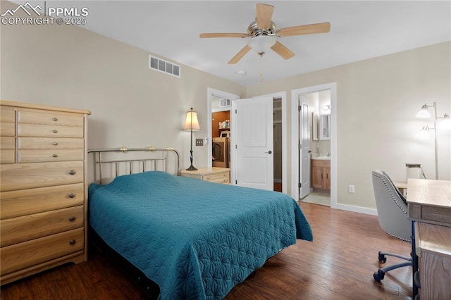 bedroom with connected bathroom, wood finished floors, visible vents, baseboards, and washer / clothes dryer