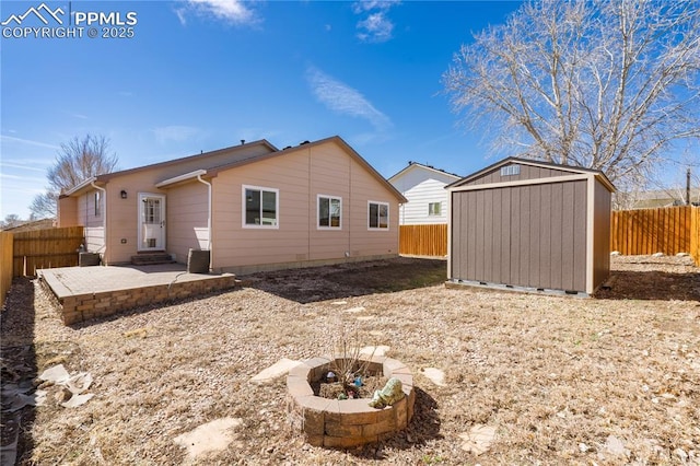 rear view of house featuring a storage shed, a patio, an outdoor structure, and a fenced backyard