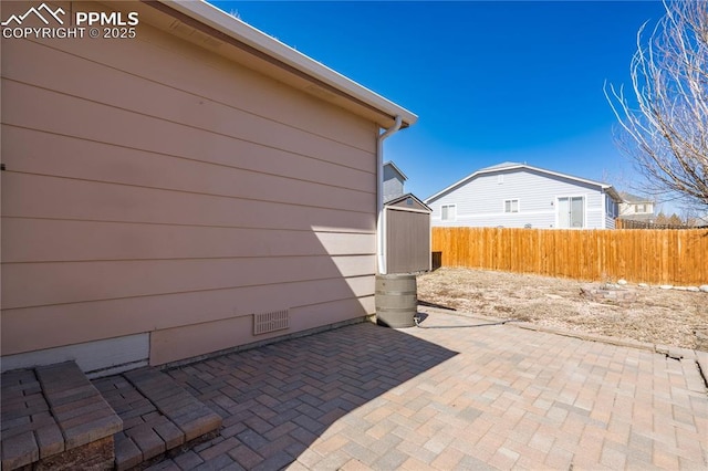 view of patio / terrace with a shed, an outdoor structure, and fence