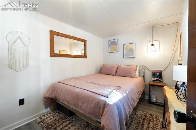 bedroom with wood finished floors and baseboards