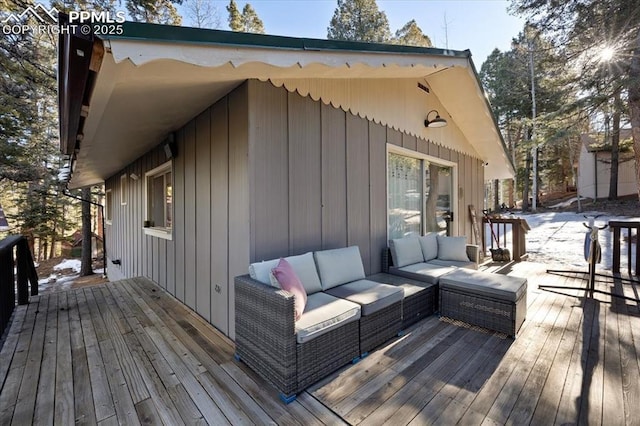 wooden terrace with an outdoor living space