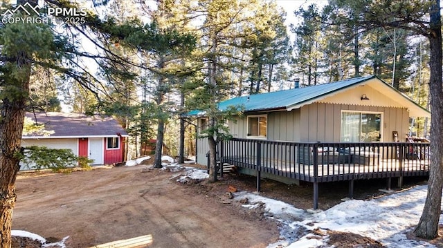 rear view of property featuring a wooden deck