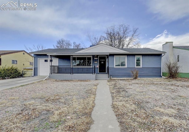 view of front of property with a garage, concrete driveway, and a porch