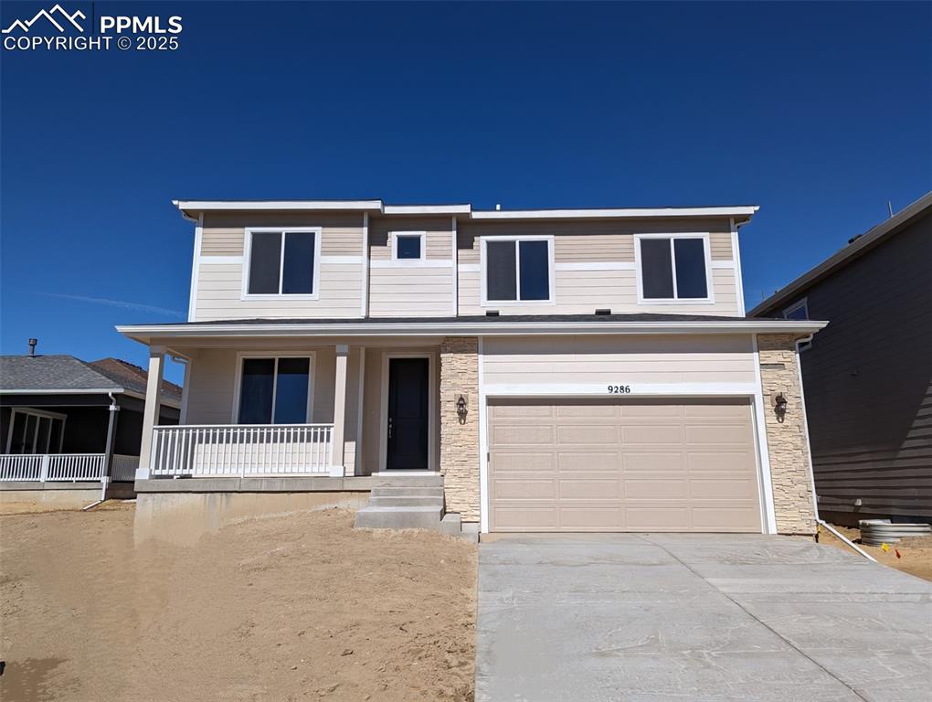 view of front facade featuring a porch, stone siding, driveway, and an attached garage