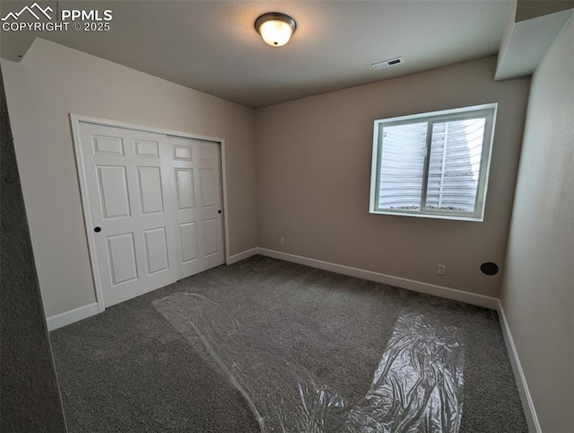 unfurnished bedroom with carpet, a closet, visible vents, and baseboards