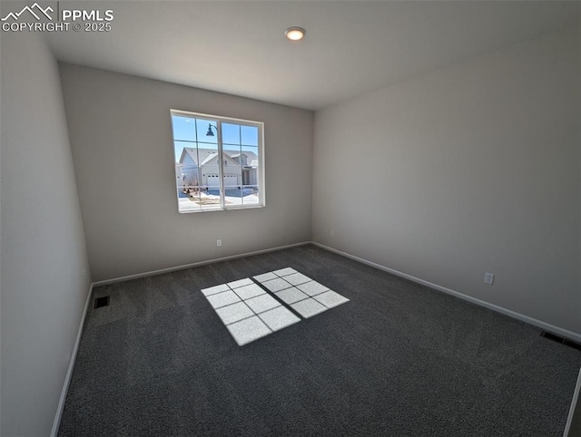 unfurnished room with baseboards, visible vents, and dark carpet