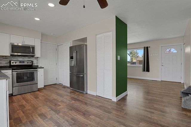 kitchen with dark countertops, white cabinets, stainless steel appliances, and dark wood-type flooring