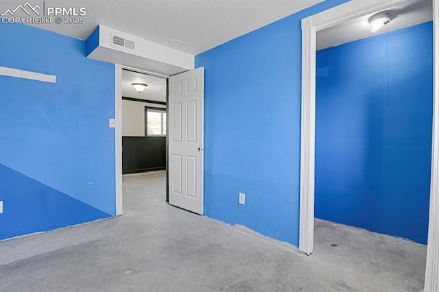 unfurnished bedroom with a textured ceiling, a closet, visible vents, and unfinished concrete floors