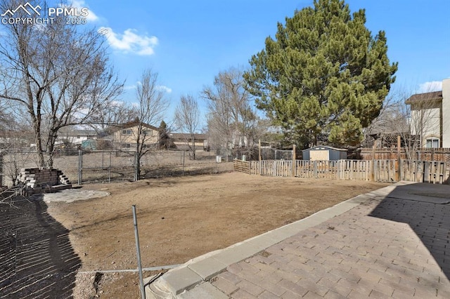 view of yard featuring fence, an outdoor structure, and a shed