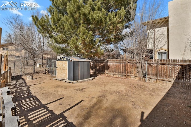 view of yard with a storage shed, an outdoor structure, and a fenced backyard