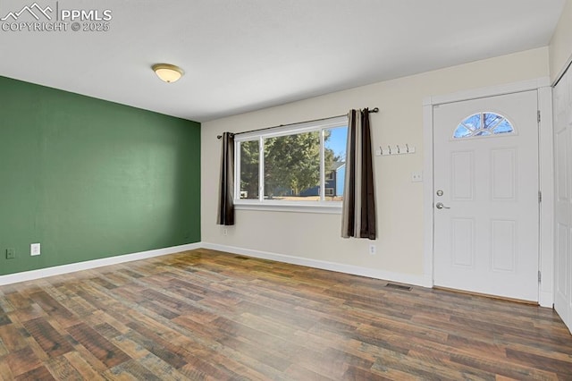 foyer entrance with visible vents, baseboards, and wood finished floors