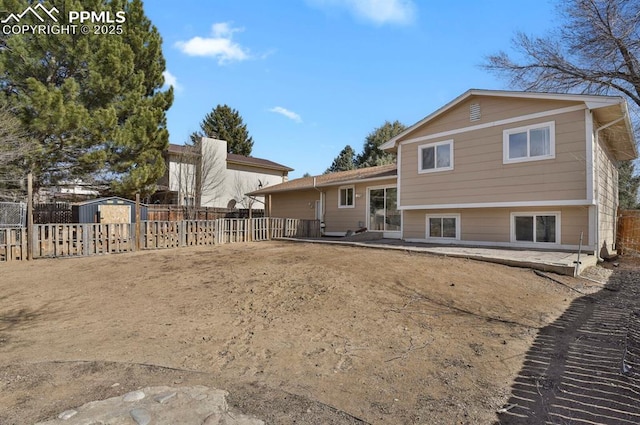 rear view of property with a patio area, a fenced backyard, an outdoor structure, and a shed