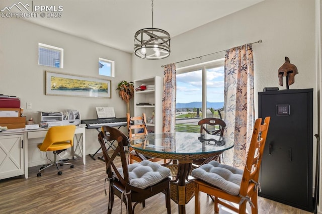 dining space featuring a mountain view, a notable chandelier, and wood finished floors