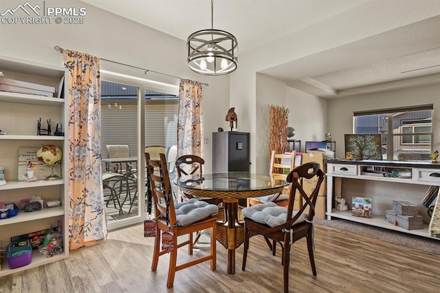 dining area with wood finished floors and a notable chandelier