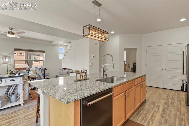 kitchen with black dishwasher, light wood-style flooring, open floor plan, a kitchen island with sink, and a sink