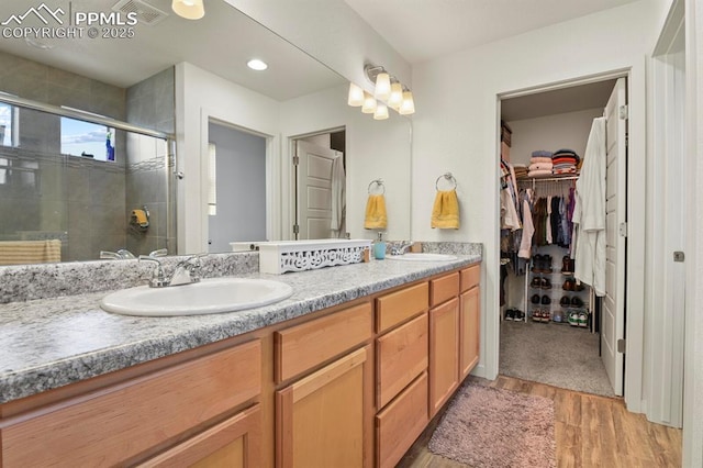 bathroom with double vanity, a sink, visible vents, and a shower stall