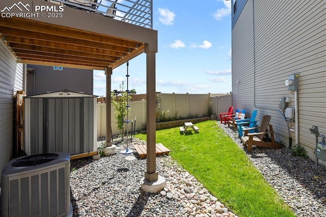 view of yard with an outbuilding, a shed, central AC unit, and a fenced backyard