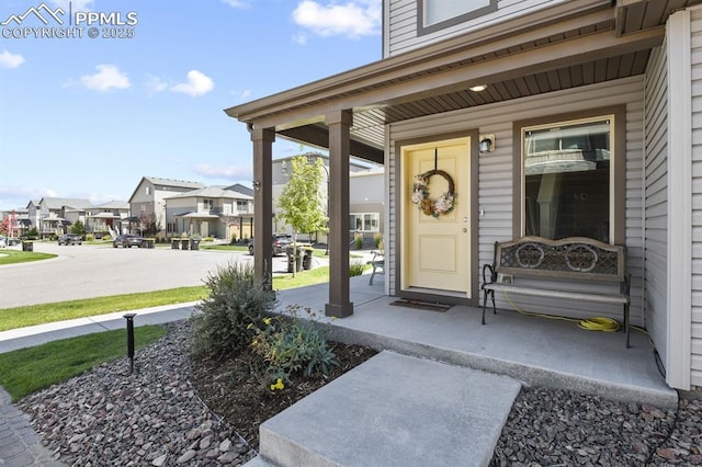 entrance to property featuring covered porch and a residential view