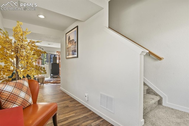 hall featuring stairway, baseboards, visible vents, and wood finished floors